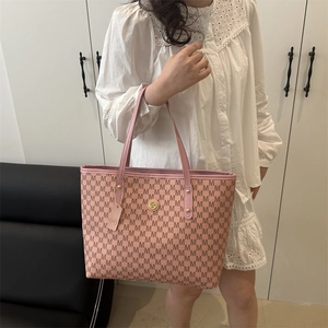 Pink vintage tote bag with all-over M-pattern and gold circular logo on long handles