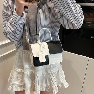 Chic black and white color-block crossbody bag with top handle and adjustable strap
