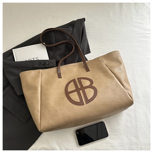 Detail of vintage pleated large tote bag with contrast logo and shoulder strap