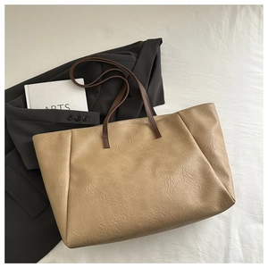 Macro shot of khaki PU leather tote bag texture with brown strap and wrinkled finish