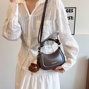 Dark brown half-moon crossbody bag with glossy leather and cute plush charm