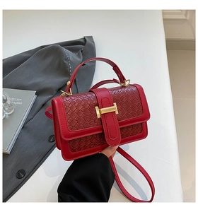 Close-up of red woven leather mini bag featuring elegant gold H-shaped metal buckle