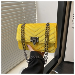 Detail der gelben Samt-Schultertasche mit V-Steppung und dunklen Metallbeschlägen