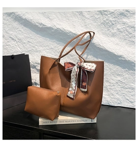 Brown tote bag and small zip pouch set with silk scarf detail on stone background