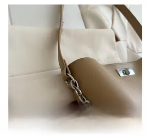 Gros plan du sac seau camel avec chaîne en métal argenté et fermoir pivotant chic