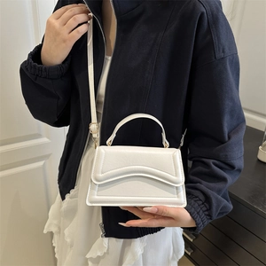 Minimalist white square handbag with quilted wave texture and golden hardware detail