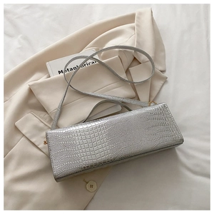 Detail of silver crocodile pattern shoulder bag with sleek metallic finish and gold hardware