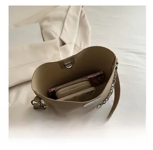 Intérieur spacieux du sac seau beige montrant le rangement pour téléphone et portefeuille