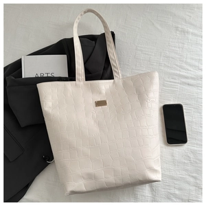Détail du sac cabas blanc crème avec motif crocodile et plaque en métal doré