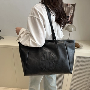 Minimalist black leather tote bag with embossed HB logo and long shoulder straps