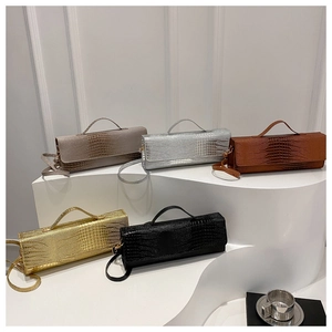 Detail of five assorted crocodile pattern handbags displayed on geometric stands