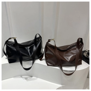 Detail of classic black and brown soft leather hobo bags with adjustable straps