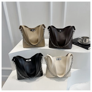 Gros plan sur quatre sacs seau élégants en kaki, marron, noir et crème avec chaînes argent