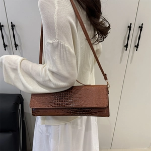 Brown faux crocodile leather shoulder bag styled with a white knitted sweater
