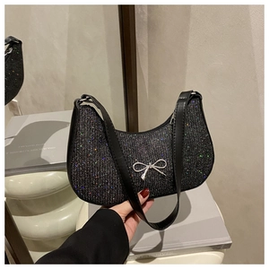 Detail of black glitter hobo bag featuring a silver metal bow and fixed shoulder strap