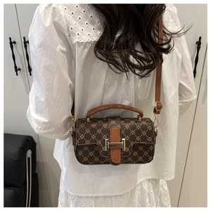 Sac bandoulière rétro marron avec motif géométrique doré porté par un mannequin au quotidien