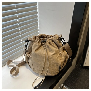 Detail der khakifarbenen Nylon-Beuteltasche mit Netz-Seitentaschen und verstellbarem Gurt