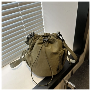 Detail der armee-grünen Nylon-Beuteltasche mit Mesh-Seitentasche und seitlicher Schnalle