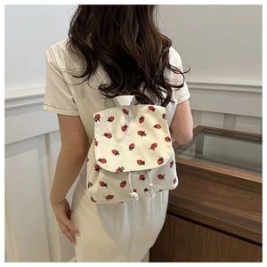 Detail showing the strawberry print and corduroy texture of the casual backpack