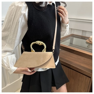 Detail of beige geometric handbag with liquid metal handle and suede leather texture