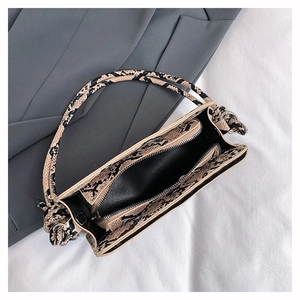 Vue intérieure du sac à main à motif serpent avec compartiment zippé et doublure noire