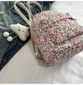 Detailansicht des rosa Blumenrucksacks mit weißem Wolkenanhänger und dünnen Trägern