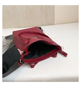 Détail du sac cabas gaufré rouge foncé montrant la doublure et la poche zippée