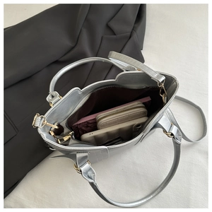 Interior view of silver tote bag showing capacity with notebook, wallet and phone