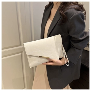 Detail of off-white envelope clutch bag featuring a gold metal buckle and wrist strap