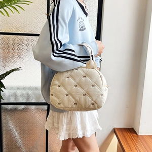 Sac à main matelassé crème avec broderies de nœuds marron et design bouffant moderne