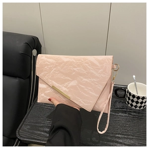 Pink pleated clutch bag featuring a gold metal trim and detachable wristlet strap