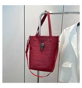 Détail du sac fourre-tout rouge foncé avec motif tête de mort en relief et ferrures