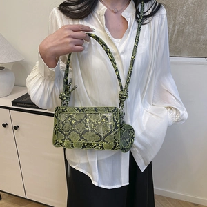 Sac bandoulière vert imprimé serpent avec sangle nouée et petit pendentif rond chic