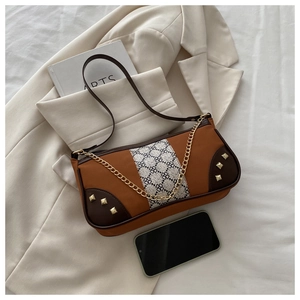 Detailed view of a caramel underarm bag with jacquard texture and gold metal studs
