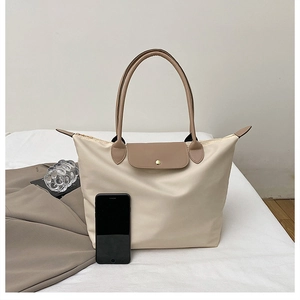 Détail du sac cabas en nylon beige avec anses en cuir marron et bouton pression doré