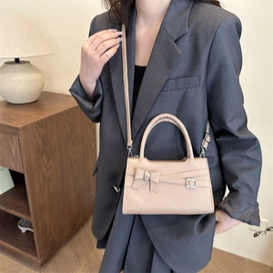 Elegant beige crossbody mini square bag with bow detail and adjustable shoulder strap