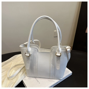 Detail of white fashion tote bag with gold metal rings and premium decorative stitching