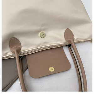 Détail macro du fermoir magnétique et des coutures sur tote bag en nylon avec anses