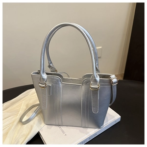 Close-up of silver tote bag showing metallic leather texture and light gold hardware