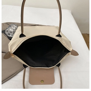 Détail du sac fourre-tout beige en nylon avec fermeture éclair et rabat en cuir brun