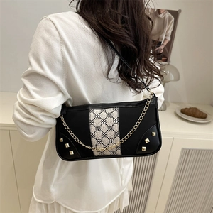 Elegant black baguette underarm bag with vintage floral pattern and gold rivets