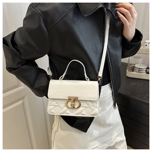 Close-up of a white textured shoulder bag with a gold lock, worn with a black jacket