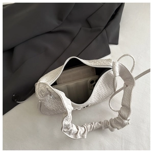 Detail shot of white woven leather handbag showing interior capacity with a phone and wallet