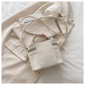 Detailed top view of white box bag with colorful silk scarf handle and golden metal hardware