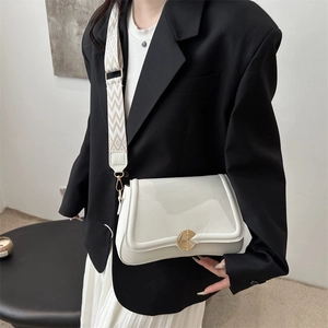 Elegante weiße Umhängetasche aus Leder mit Jacquard-Gurt an einem modischen Model