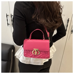 Detail of fuchsia quilted handbag showing gold chain handle and metal buckle on back
