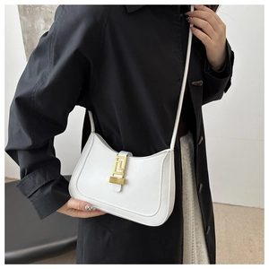 Détail d'un sac à main blanc courbé en cuir avec une boucle métallique dorée géométrique