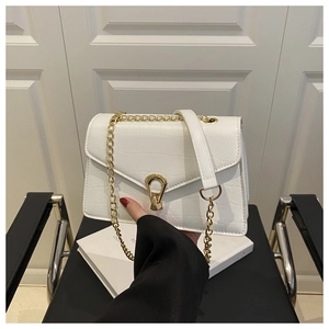 Close-up of white croc-embossed leather bag with gold chain and unique metal lock detail