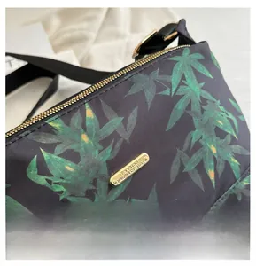 Close-up of lightweight tote bag with green leaf print and golden metal zipper