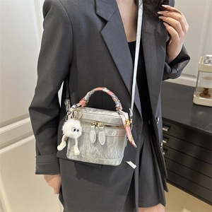 Silver-grey mini box crossbody bag with marble texture and plush monster charm